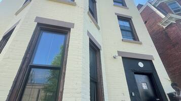 Un immeuble à plusieurs étages, doté d’une façade sobre, de grandes fenêtres et d’une porte noire.