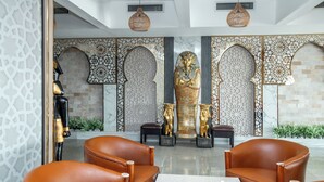 A lobby with a central statue, seating area, and decorative wall panels. - Hotel Comfort Giza (Giza)