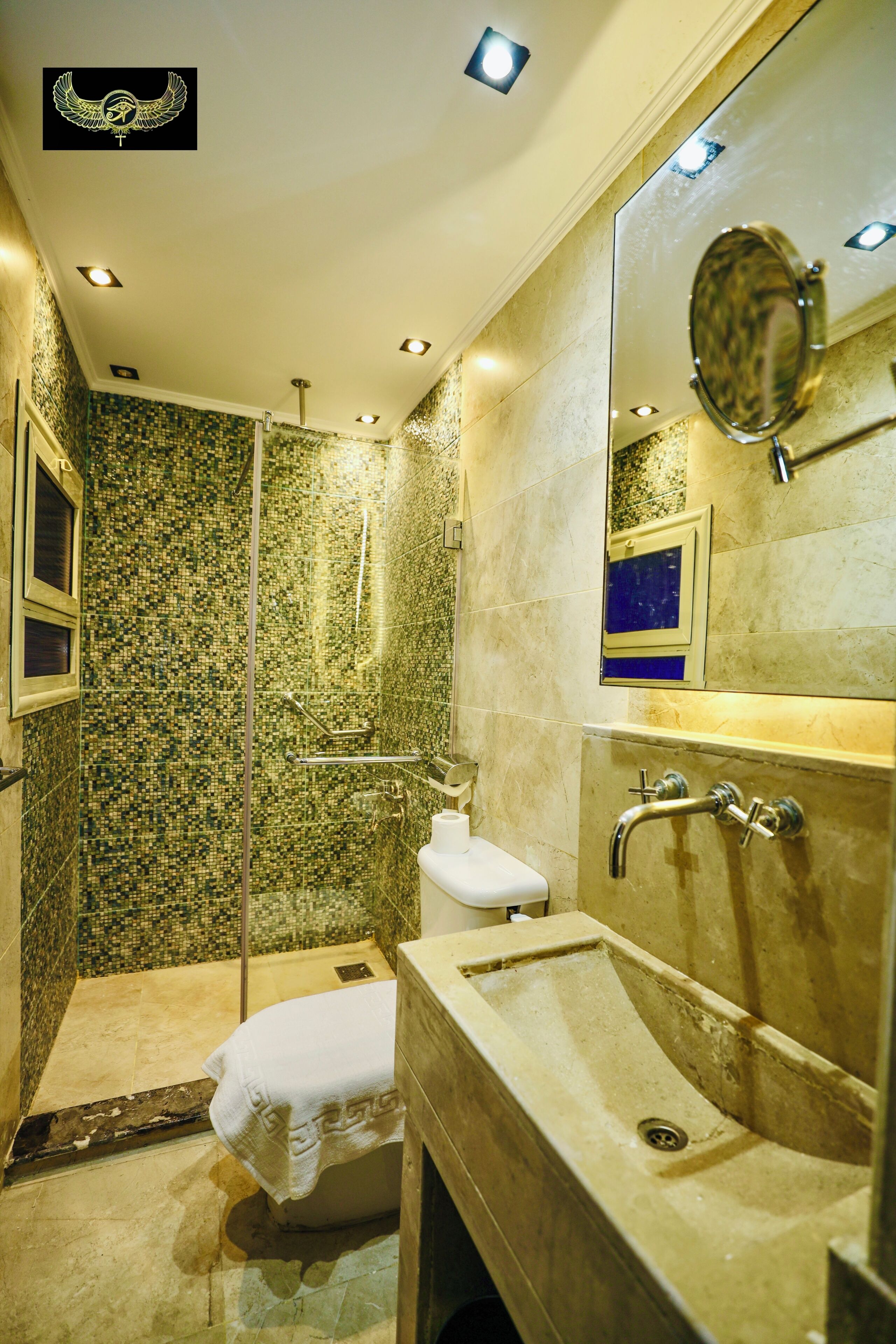 Un baño con ducha, lavabo, espejo y toalla.