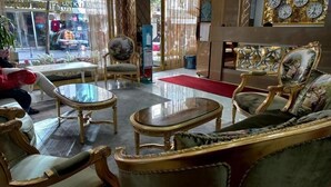A lobby with ornate furniture, a glass coffee table, and a red carpet.