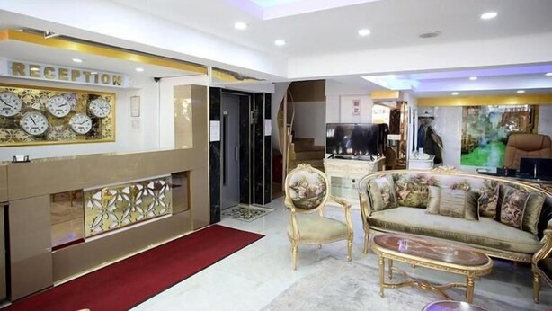 A reception area with a reception desk, a sofa, and a chair.