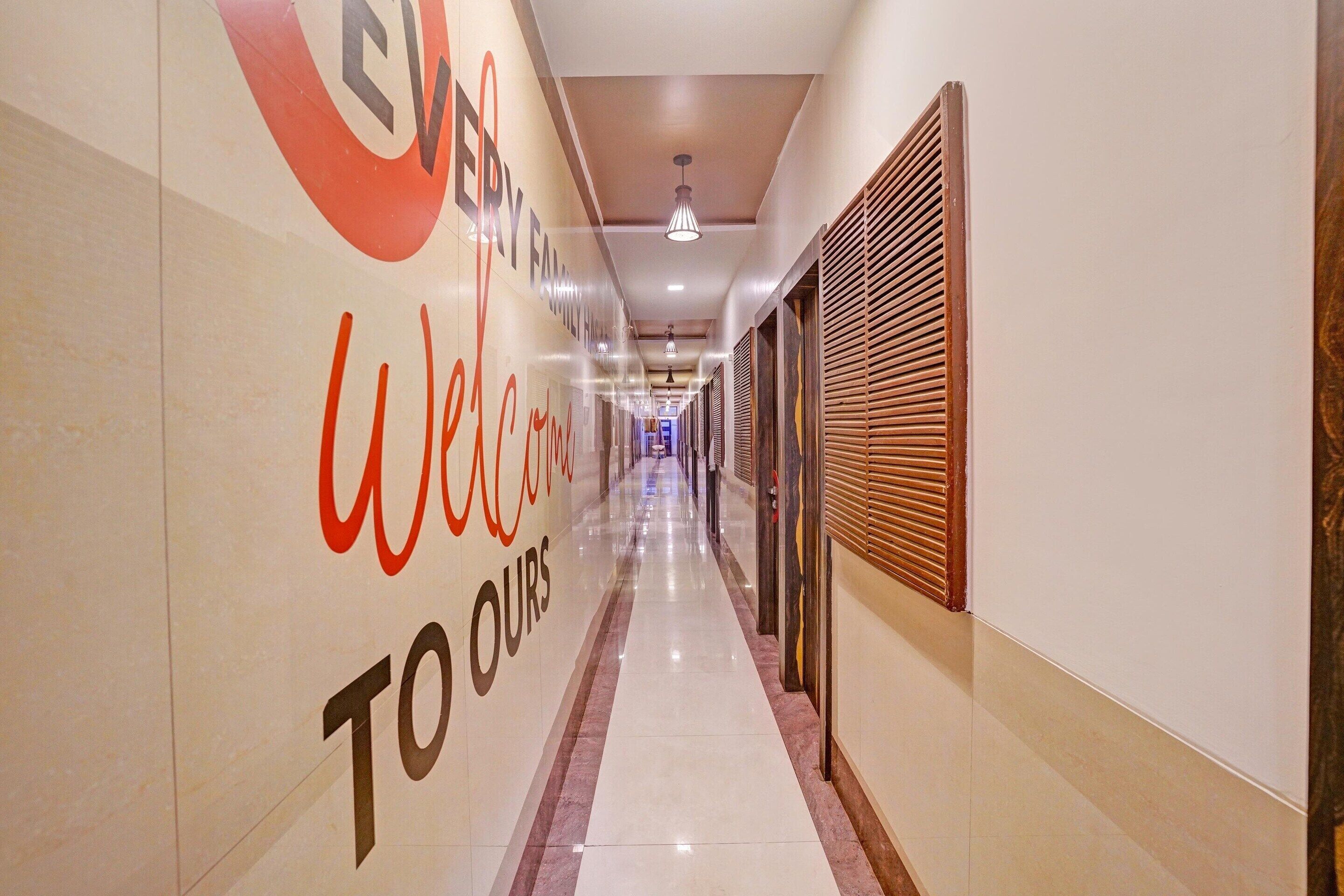 Pasillo de hotel con un cartel que dice 'Welcome to our', suelo de baldosas e iluminación empotrada en el techo.