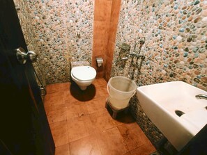 Casa de banho com sanita, bidé e lavatório.