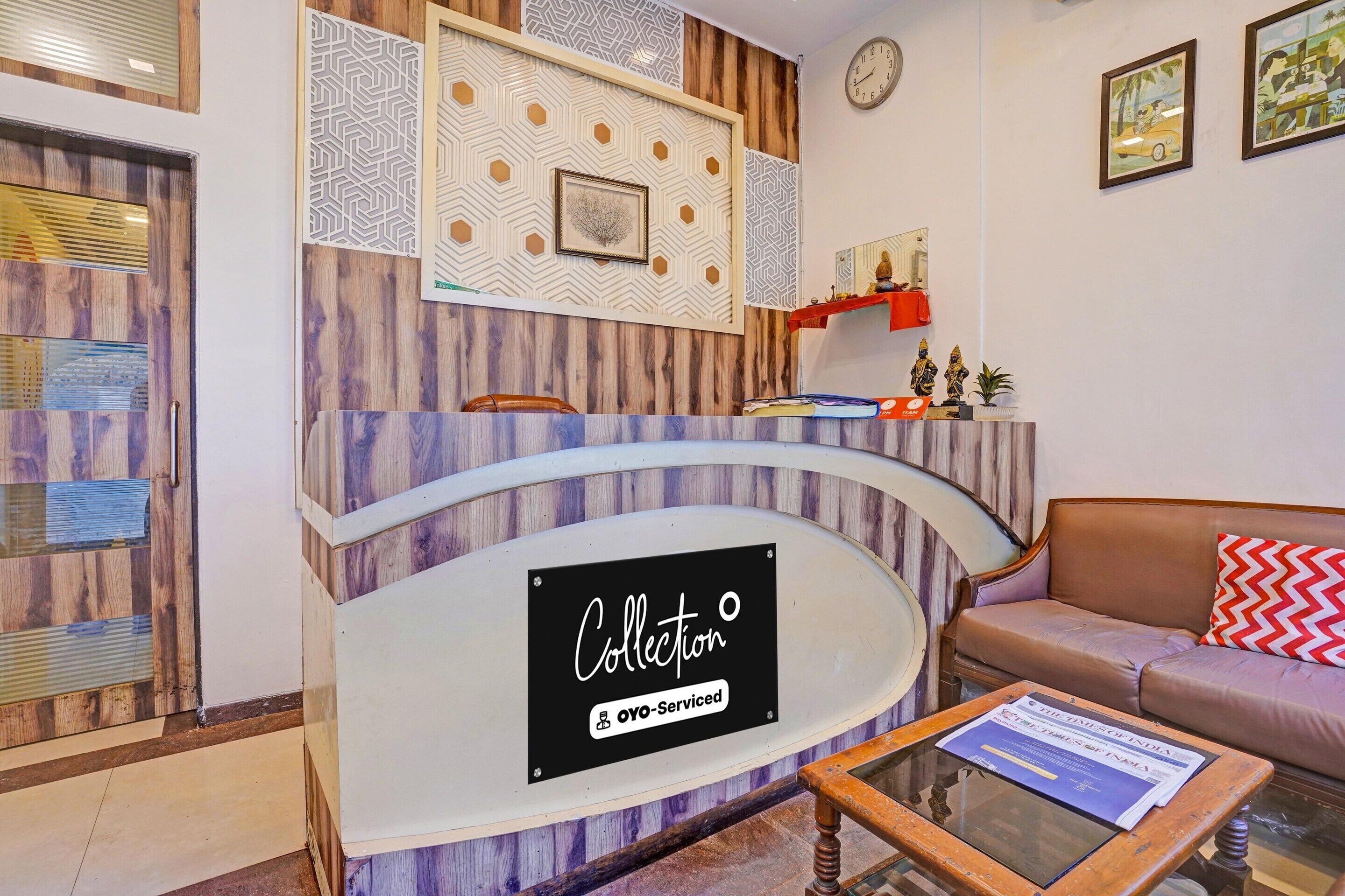 A reception desk with a sign reading 'Collection OYO-Serviced' and a clock on the wall.