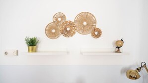 Una pared decorada con arte, una planta en maceta, un globo terráqueo y una lámpara.