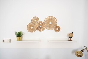 Eine Wand mit dekorativer Wandkunst, einer Topfpflanze, einem Globus und einer Lampe.