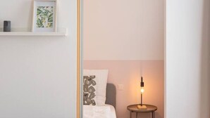 Un dormitorio moderno con cama, mesita de noche y lámpara.