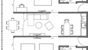 Plano de planta que muestra un comedor, cocina, dos dormitorios y un baño.
