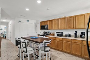 A kitchen with wooden cabinets, a microwave, a toaster, and a coffee maker. - Gulf Breeze Coastal Cottage*Beach* Shopping*Dining (Gulf Breeze)