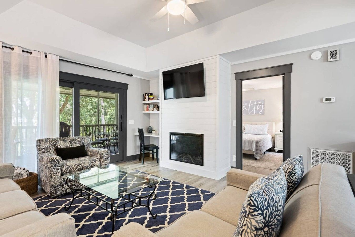 A modern living room with a glass coffee table, a sofa, and a fireplace.