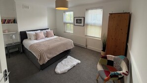 A bedroom with a bed, bedside tables, a chair, a radiator, and a window with blinds. - Spacious 3 dbl bed house - sleeps 7! On the High St, 10 min walk to East Croydon (Croydon)