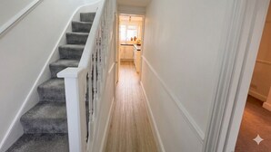 A staircase leading to a kitchen with white walls and a wooden floor. - Spacious 3 dbl bed house - sleeps 7! On the High St, 10 min walk to East Croydon (Croydon)