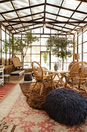 A greenhouse-style room with a table, chairs, and potted plants. - Luxury Wine Country Estate Near Downtown/Wineries (Paso Robles)