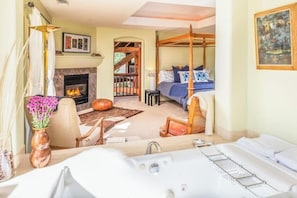 A bedroom with a four-poster bed, a fireplace, a sitting area with a chair and table, and a view of the outside. - Luxury Wine Country Estate Near Downtown/Wineries (Paso Robles)