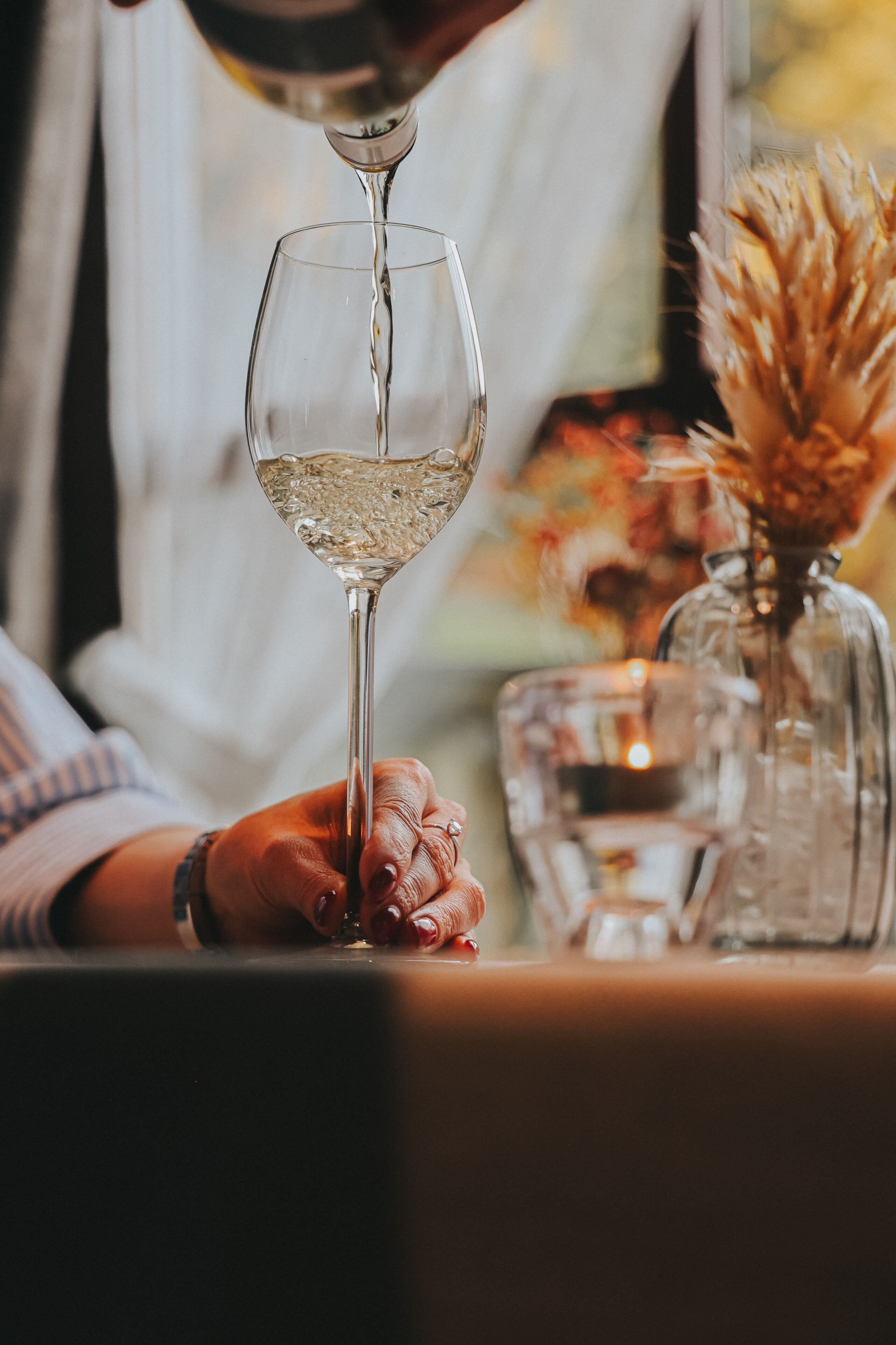 A person pouring a clear liquid into a glass.