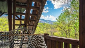 A wooden deck with a hammock and a view of a forest and mountains. - Postcard-worthy views, 4 Decks, Jetted Tub (Burnsville)