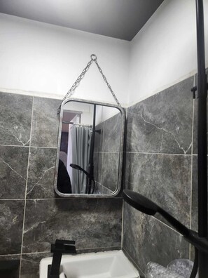 Een douche, handdoeken, zeep, toiletpapier