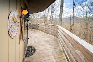 A wooden deck with a railing, a door, and a decorative sign. - Timber Ridge Sugar Mountain Condo. Sleeps 8. (Sugar Mountain)