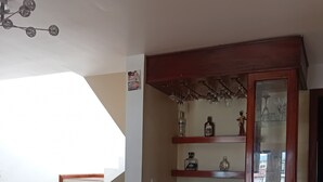 Eine Treppe mit Holzsitzen und rotem Akzent, ein Holzschrank mit Glastüren sowie ein gepolsterter Hocker.