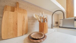 Una cocina con tabla de madera, un portalápices y un plato pequeño.