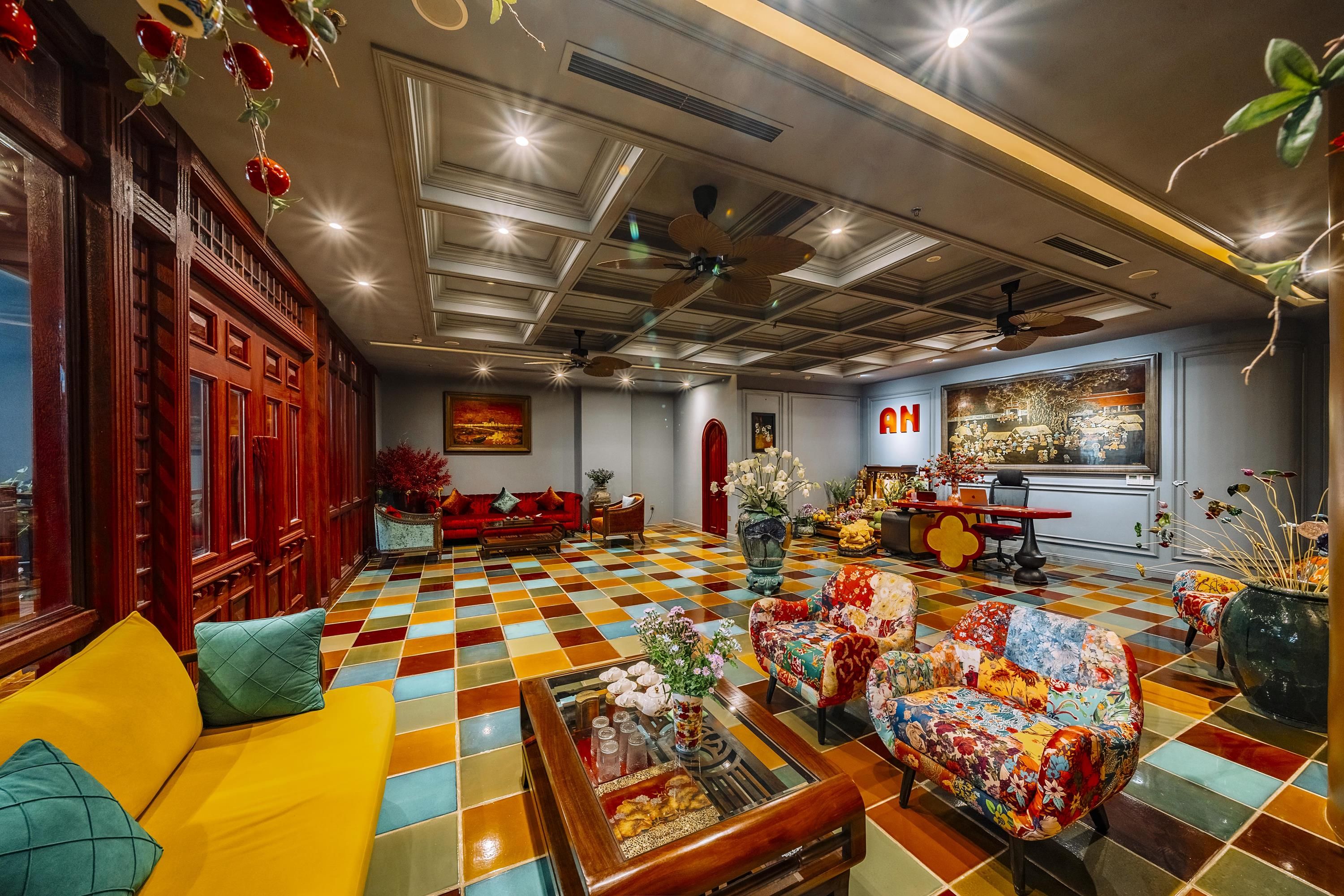 A hotel lobby with a checkered floor, wooden furniture, and a large 'AN' sign on the wall.