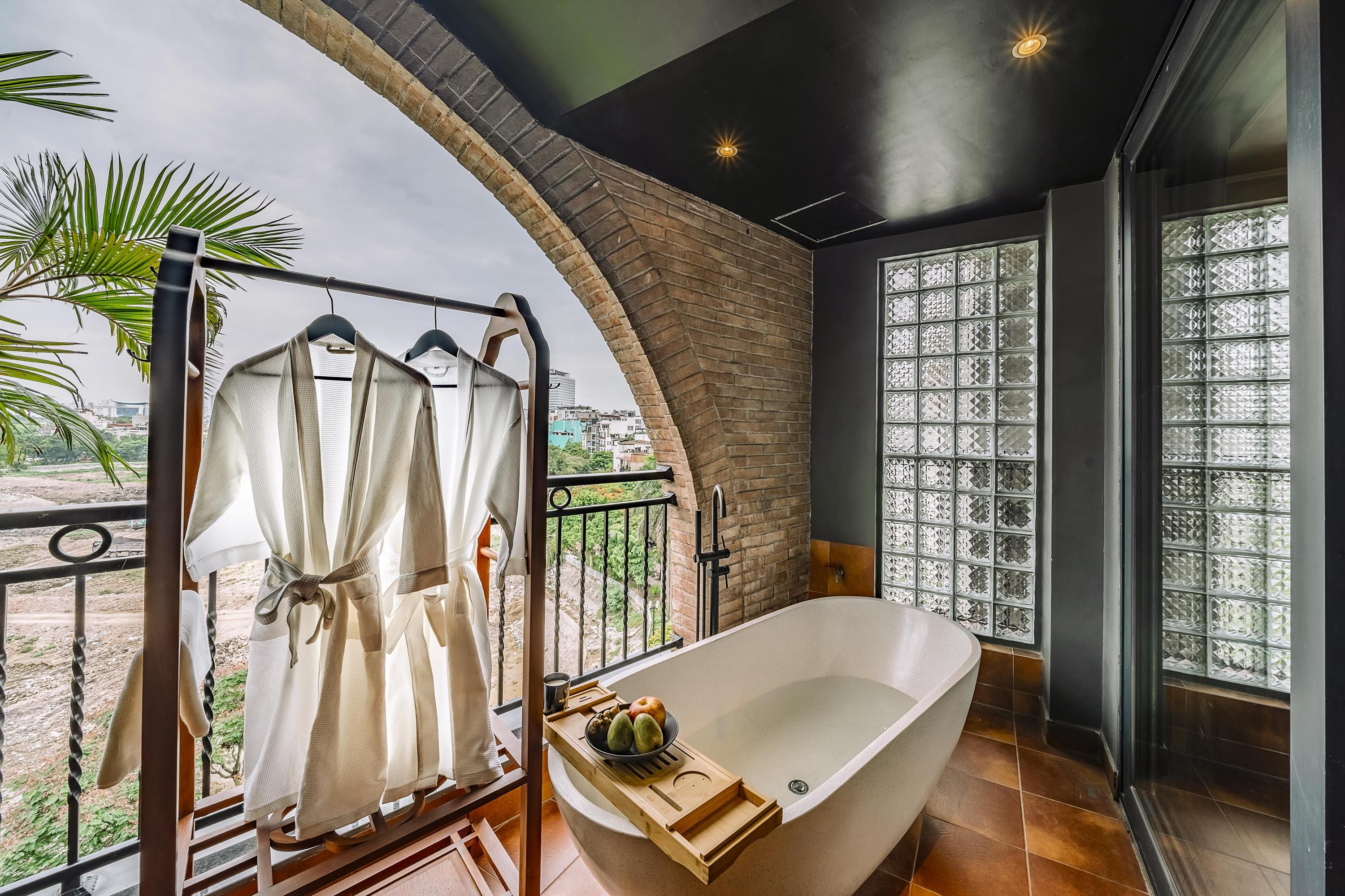 Un baño moderno con una bañera independiente, cabina de ducha con mampara de vidrio y vistas a la ciudad.