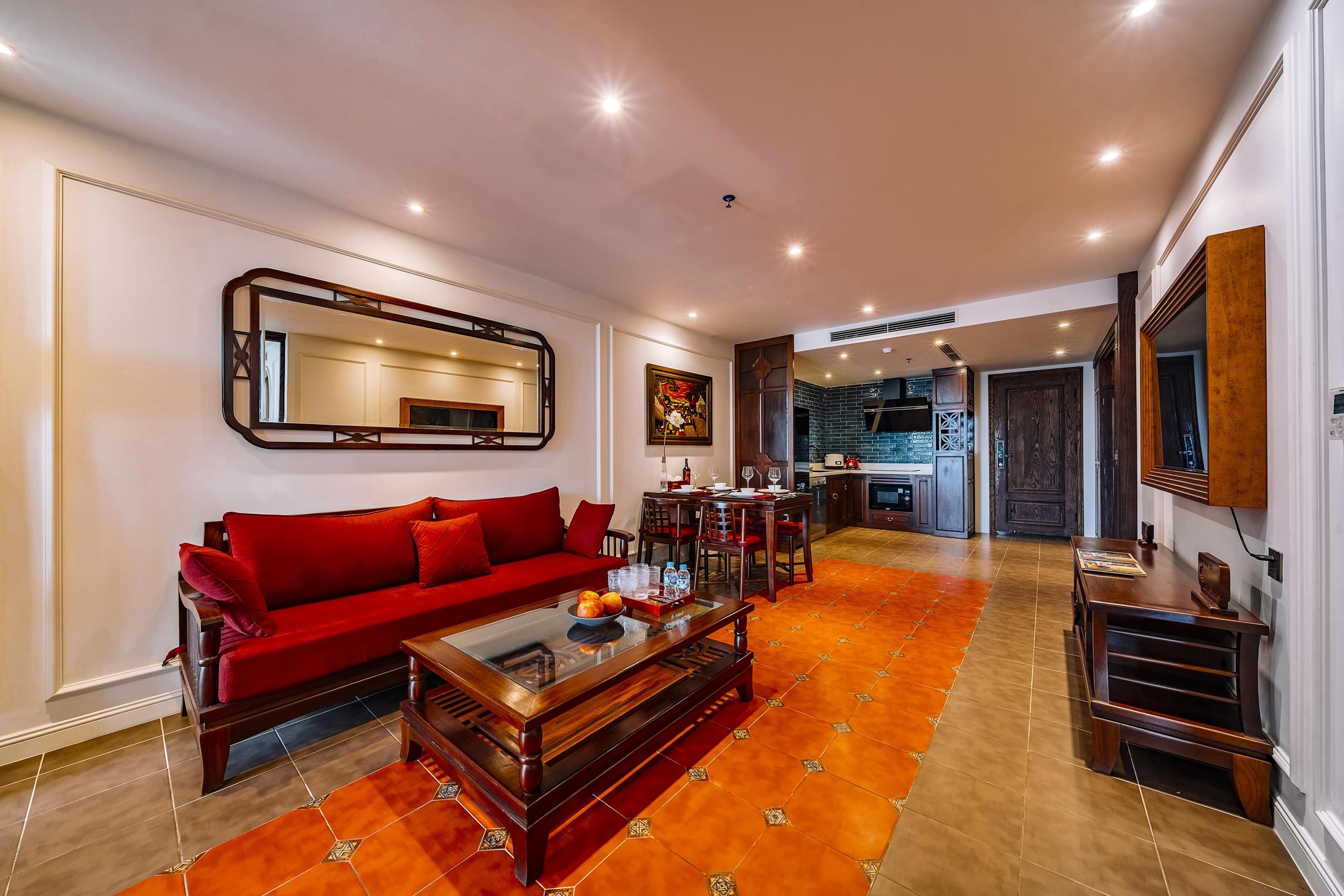 Uma sala de estar moderna com um sofá vermelho, uma mesa de centro e um espaço de jantar com uma mesa de madeira e cadeiras.