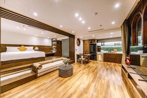 Ein Hotelzimmer mit Bett, Sitzecke und Küchenzeile.