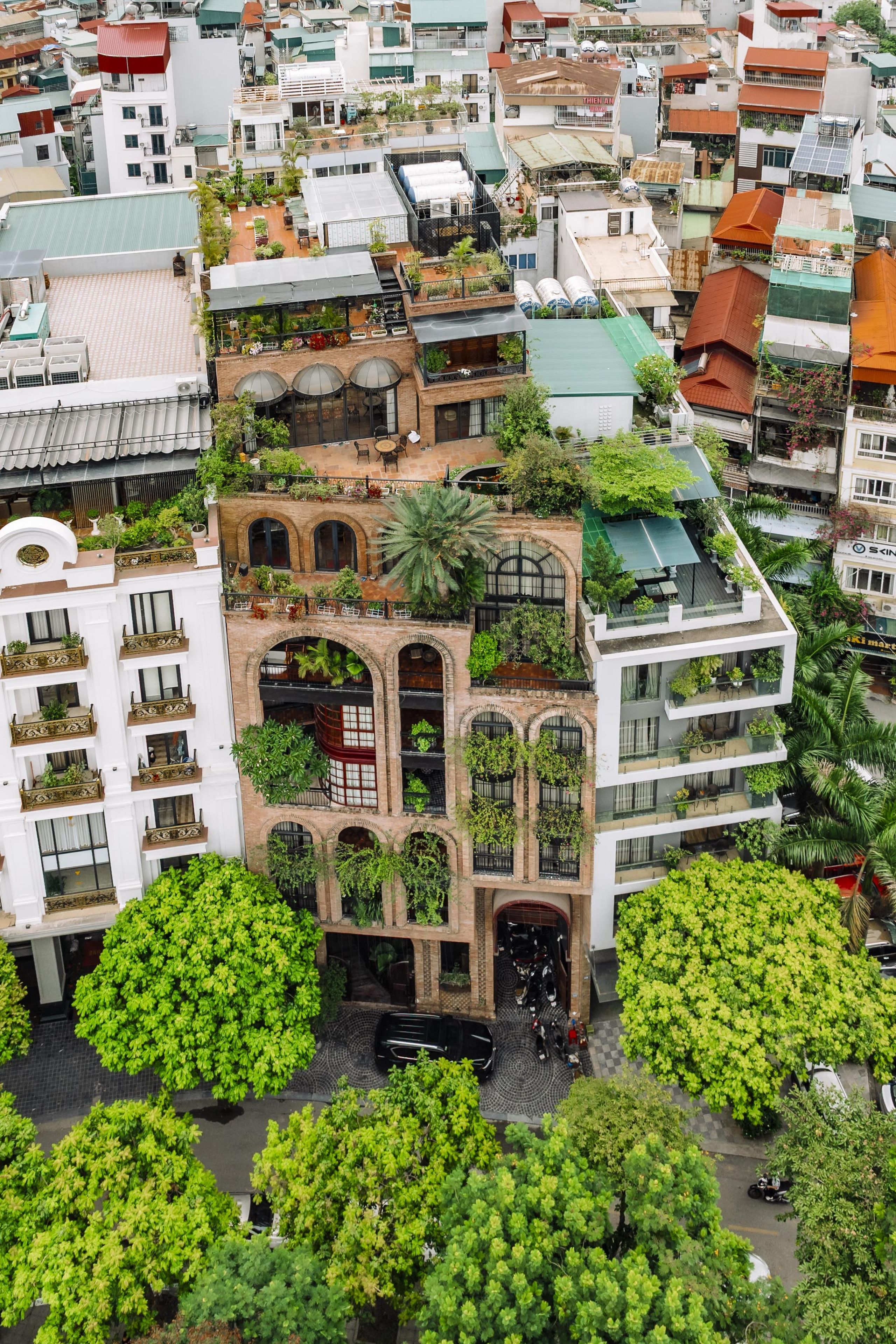 A multi-story building with balconies, a rooftop garden, and a mix of architectural styles.