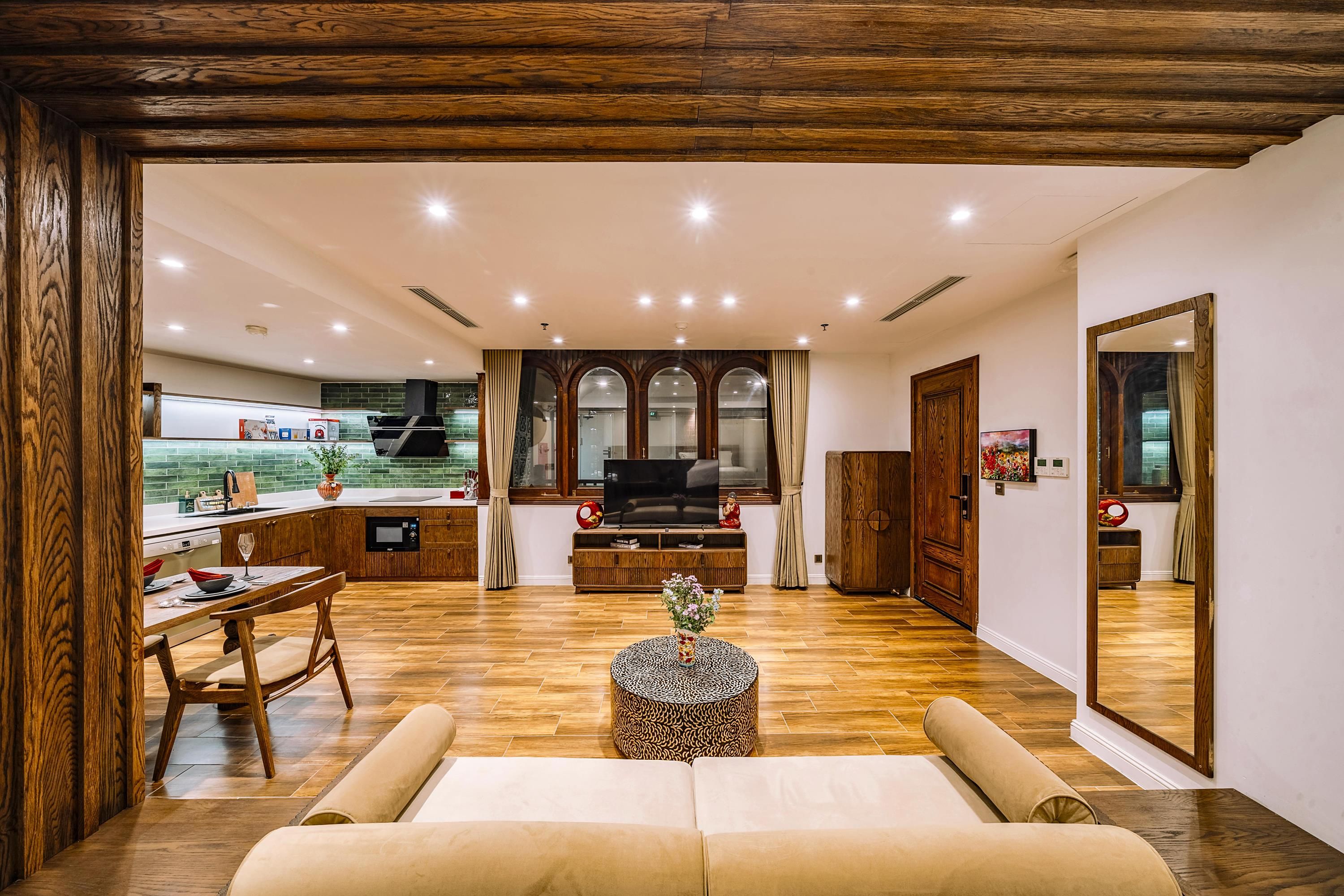 A modern living room with a sofa, a TV, and a dining area with a table and chairs.