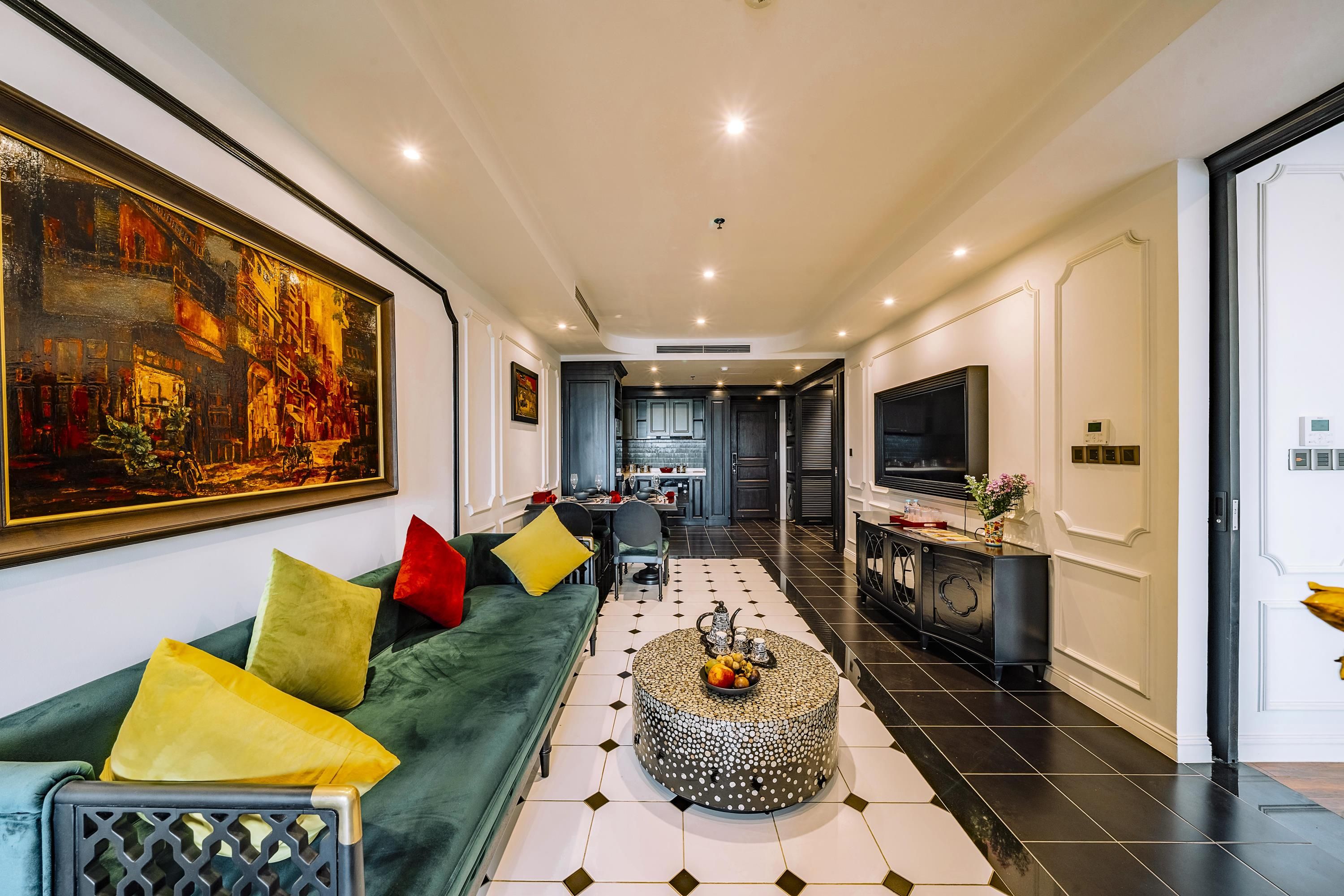 A modern living room with a sofa, a coffee table, and a large painting on the wall.
