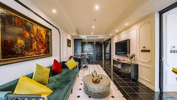 A modern living room with a sofa, a coffee table, and a large painting on the wall.
