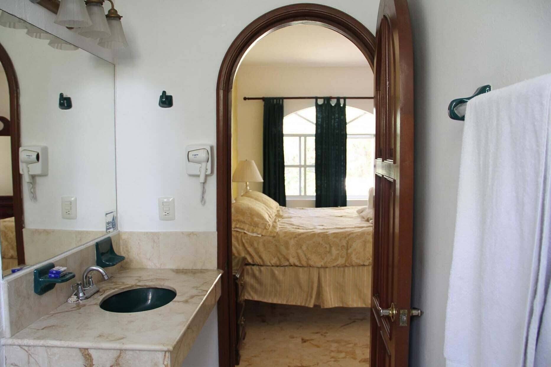 A bathroom with a sink, mirror, and towel rack.
