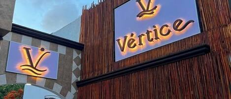 A building with a vertical wooden facade and a sign that reads 'Vertice'.