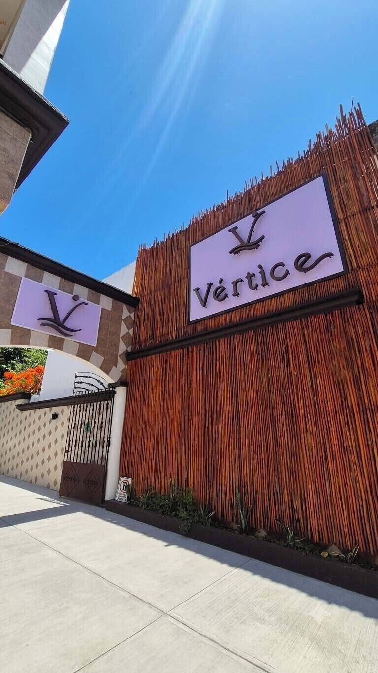 A building with a sign that reads 'Vértice' and a logo resembling a stylized 'V'.