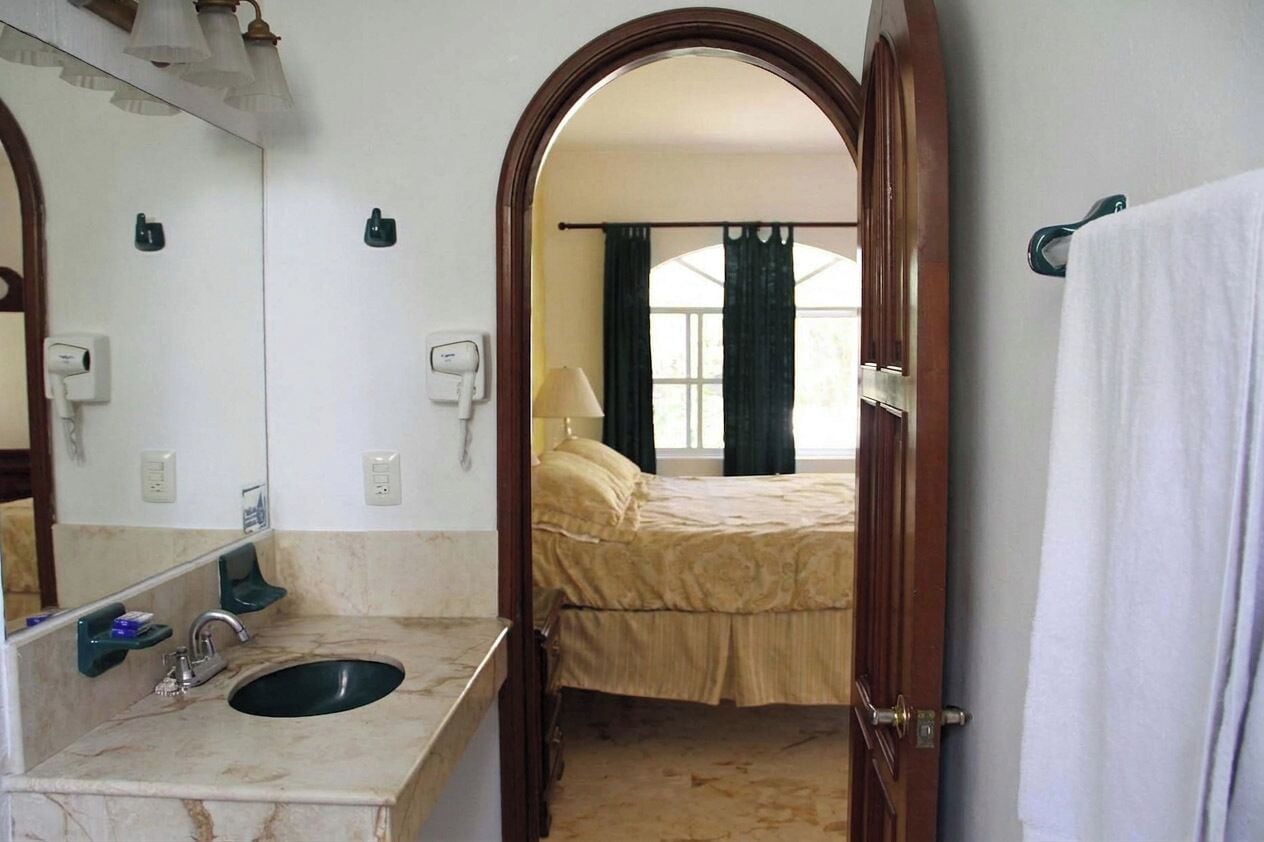 A bathroom with a sink, mirror, and towel rack.