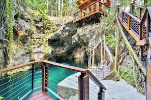 Eine natürliche Felsformation mit einer Holzbrücke und einem Becken.