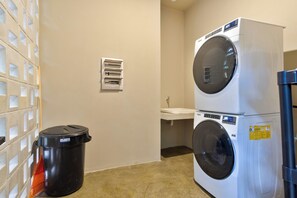A laundry area with a washer and dryer, a trash bin, and a utility panel on the wall. - Luxury Jungle Villa - 4 Bedrooms - Private Pool and Cenote in a gated community (Puerto Morelos)
