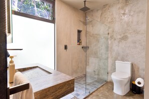 Ein Badezimmer mit Duschkabine, Marmorwaschbecken und Toilette.