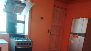 Uma cozinha com fogão, forno e geladeira.