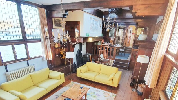 A cozy living room with two yellow sofas, a wooden coffee table, and a chandelier. - Historic Houseboat Stay for 7 (Naarden)