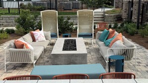 A patio with two sofas, a coffee table, and wicker chairs.