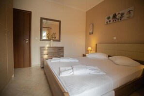 Ein Hotelzimmer mit einem Bett, einem Schminktisch, einem Spiegel, einem Nachttisch und einer Wanduhr.