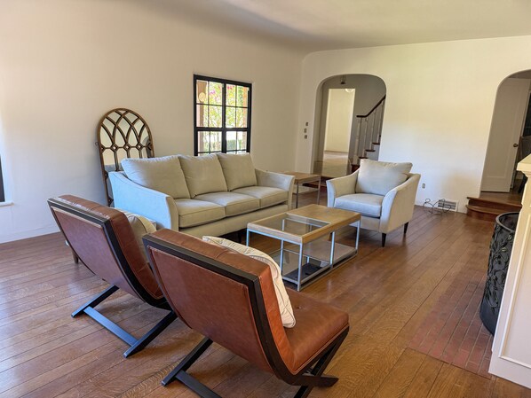 A living room with a sofa, two armchairs, a coffee table, and a staircase leading to another level. - Historic 3-bedroom house on Main st  in charming Sutter Creek (Sutter Creek)