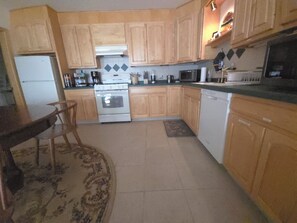 A kitchen with wooden cabinets, a refrigerator, an oven, a microwave, and a dishwasher. - A private apartment on six acres, with a view no other listing in Gardiner has. (Gardiner)