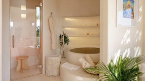 Un baño moderno con cabina de ducha de vidrio, una bañera y un taburete pequeño.