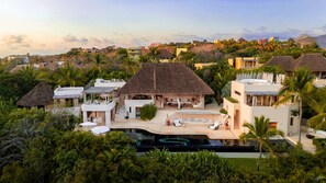 A resort with multiple buildings, a swimming pool, and lush greenery.