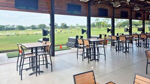 An outdoor covered area with tables and chairs, a view of a golf course, and a wooden ceiling structure. - 4BR 3Bath Pool Home with Golf Course View, Quiet Cul De sac in Southern Dunes (Haines City)