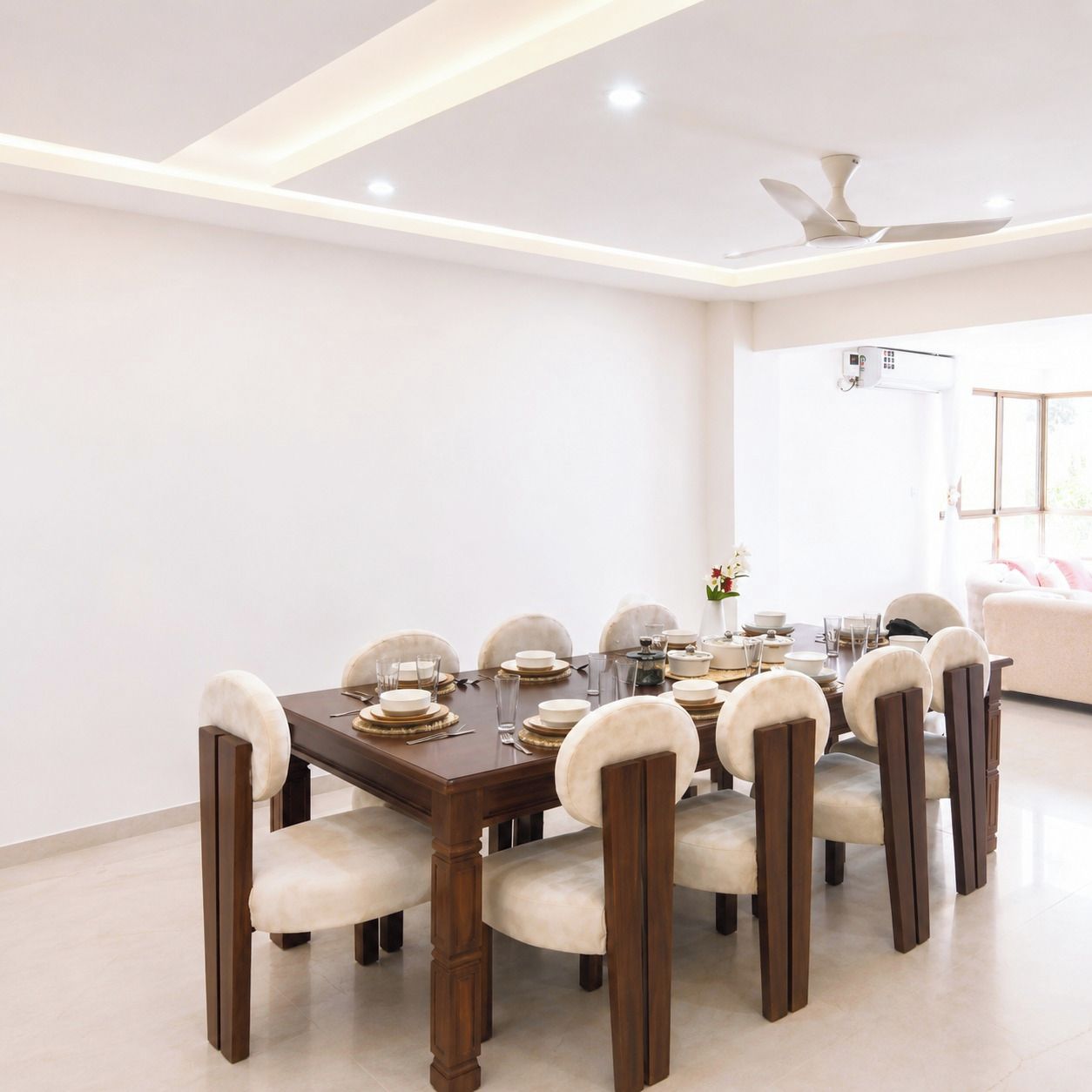 A dining area with a wooden table set for eight, surrounded by upholstered chairs.