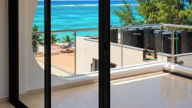 Ein Balkon mit Blick auf den Ozean und Palmen.